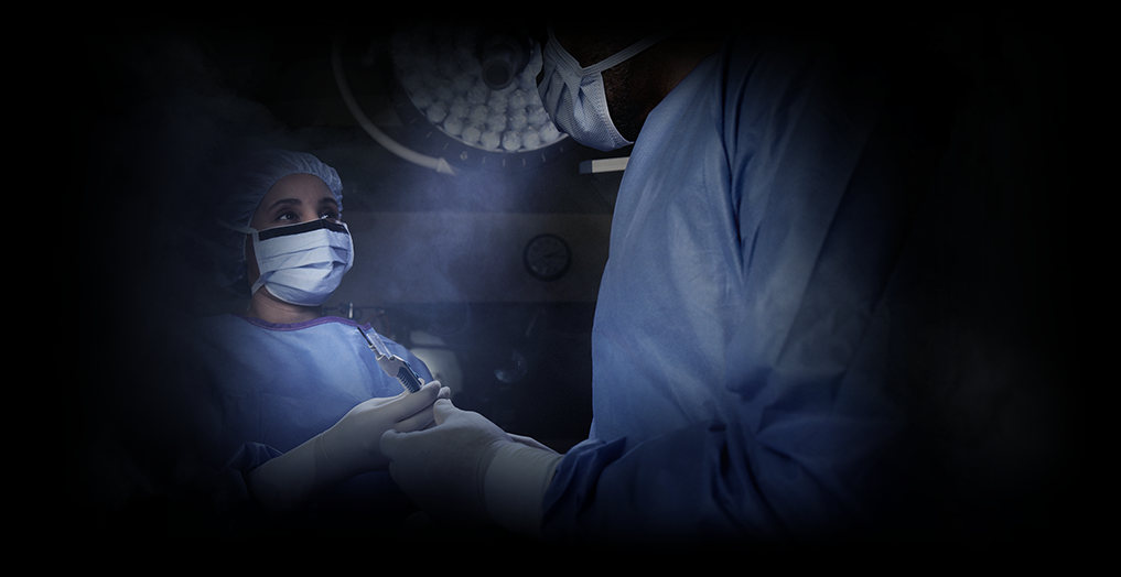 Una enfermera y una cirujana se miran una a otra en un entorno de quirófano
