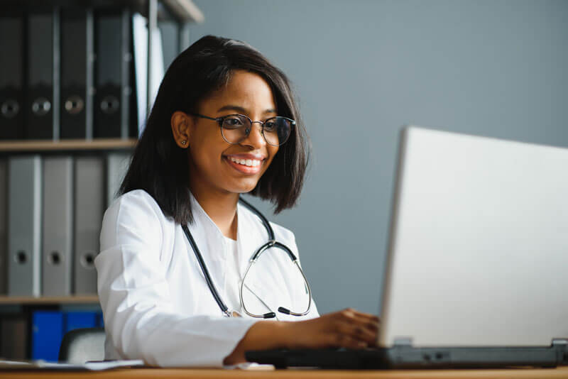 Doctor watching a webinar on their laptop