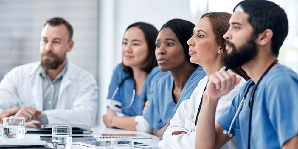 Doctors sitting at tablet and  paying attention