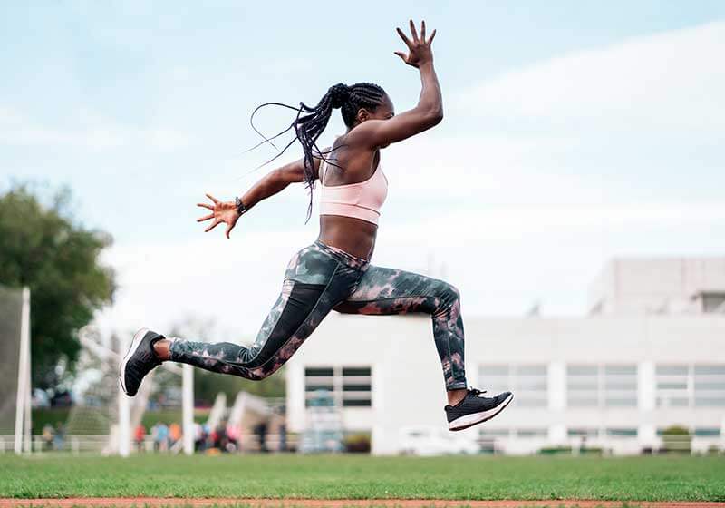Woman in mid sprint running on the track