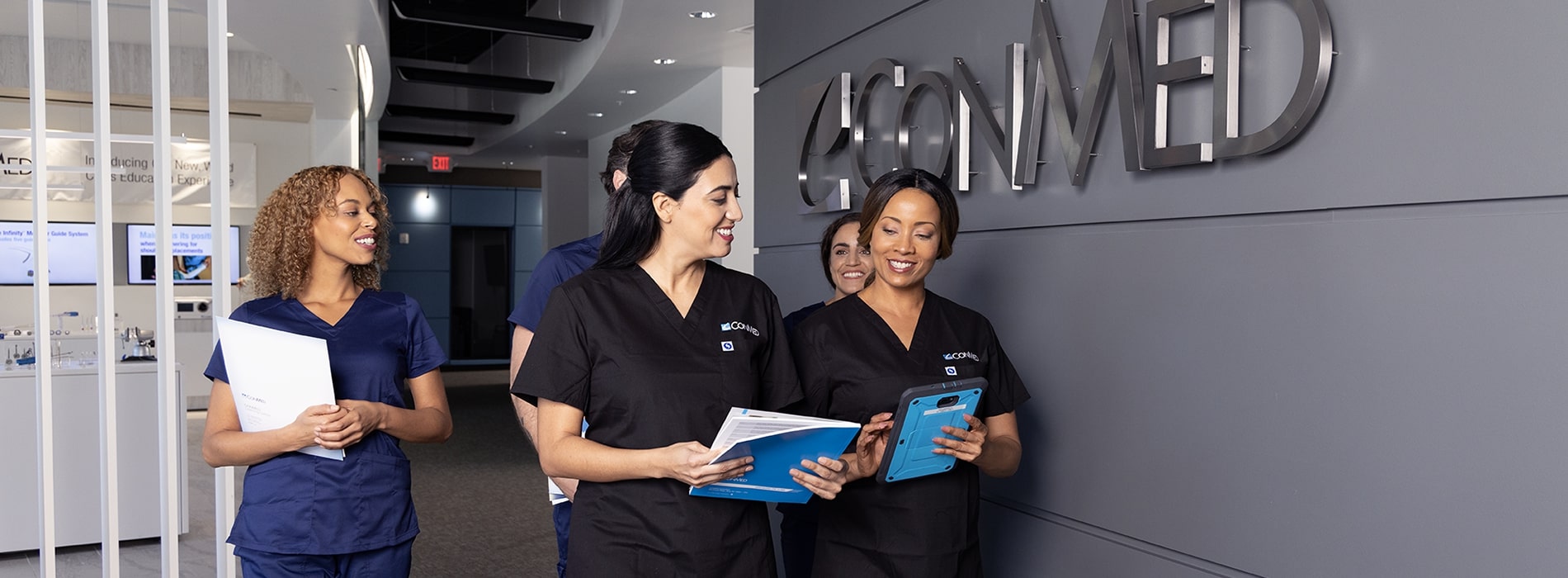 a small group of conmed professionals walking down the hall at the Largo Medical Edcuation Center