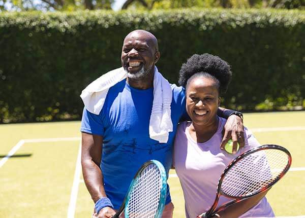 happy senior couple playing tennis