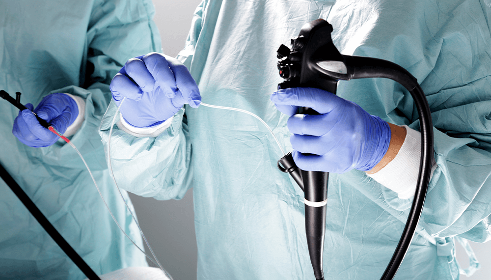 hands wearing latex gloves handling a medical device