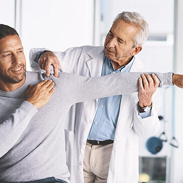 El médico está realizando un examen del manguito rotador a un paciente.